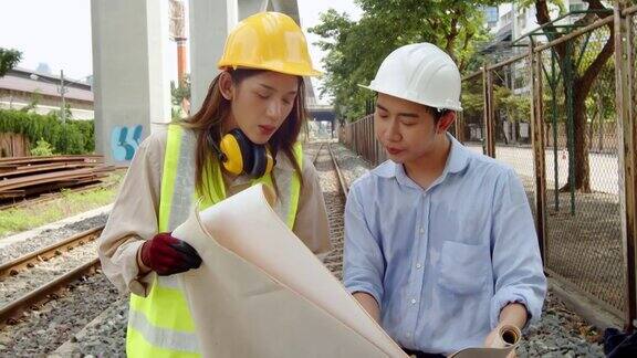 两名男工程师和女检查员检查火车轨道的状态铁路工程