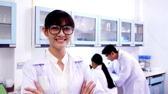 在实验室工作的研究科学家团队年轻的女研究科学家看着迷人的微笑4k决议
