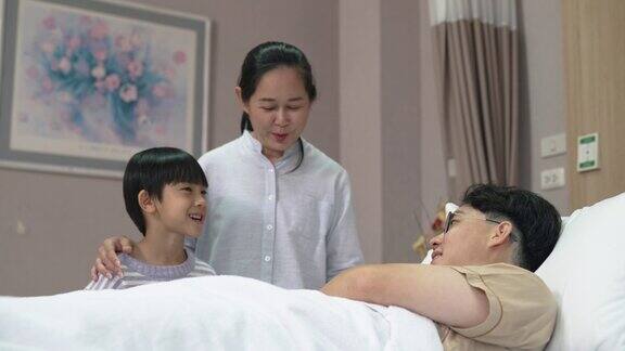 年轻的亚洲男子被他的母亲和兄弟访问而他的疾病在医院康复