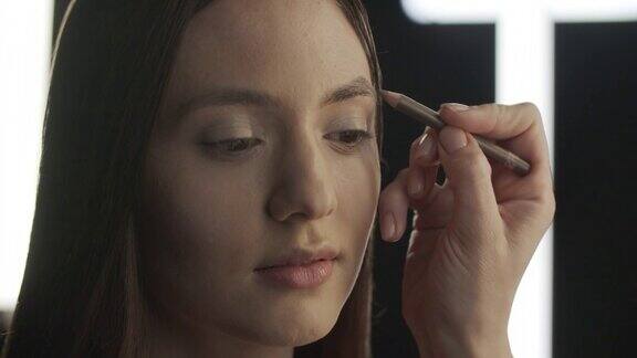 化妆的步骤化妆师用铅笔画这个女孩的眉毛
