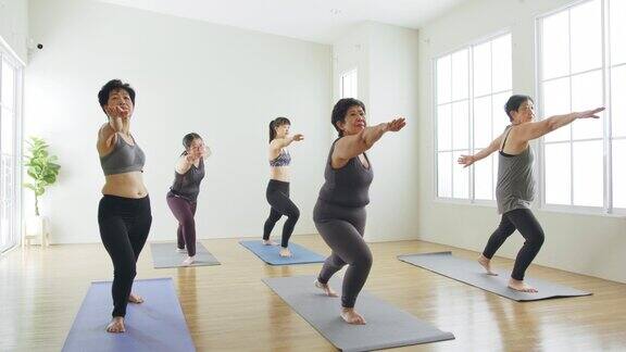 一群亚洲女性几代人在健身房锻炼和练习瑜伽