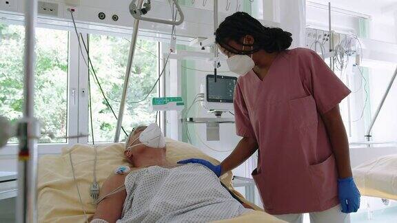 在重症监护病房护士看着老年病人的生命体征监视器