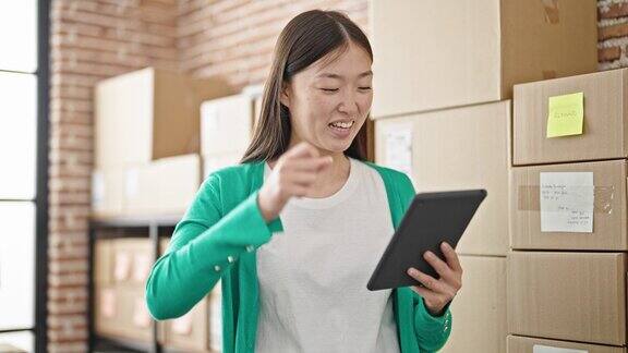 年轻的中国电子商务女员工在办公室用触控板脸上带着胜利者的表情