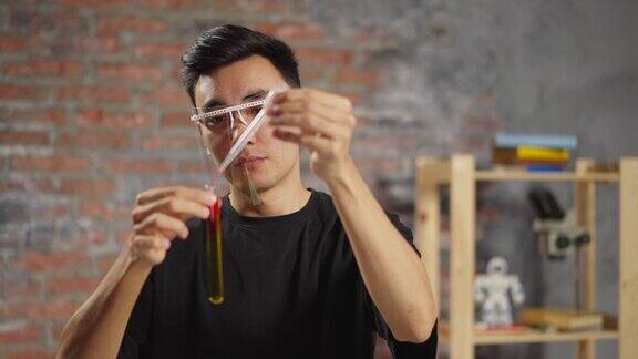 亚洲化学家在实验室用黄色液体在试管中添加试剂