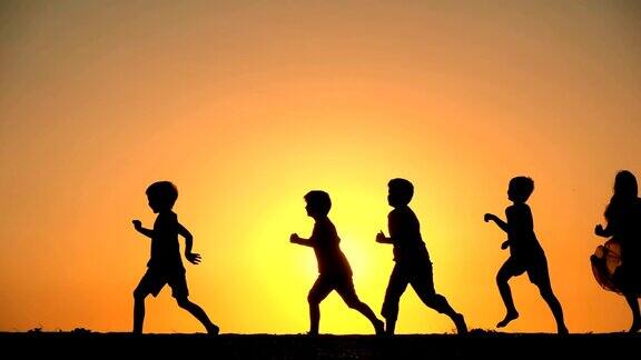 五个孩子迎着夕阳奔跑的剪影