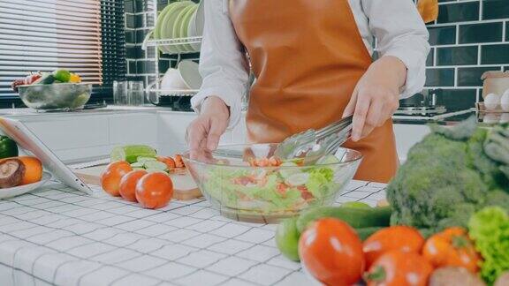 一名素食妇女在厨房做饭时用碗搅拌蔬菜沙拉