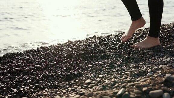 近距离拍摄了那个女人的脚她光着脚在石滩上漫步
