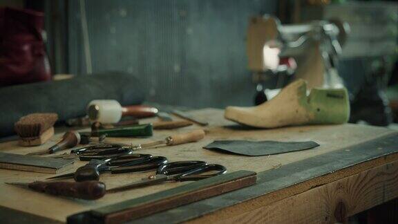看工匠的桌子上摆满了不同的制鞋工具