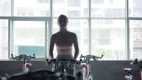 女人们在健身房骑自行车锻炼