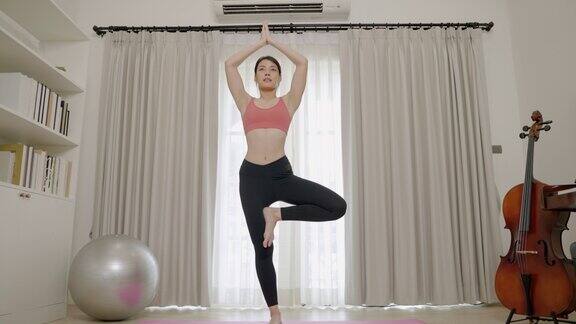 亚洲妇女在家中做瑜伽时的柔韧性训练