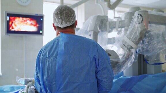 外科医生在监视器上的后视图机器人设备在现代的手术室里进行手术
