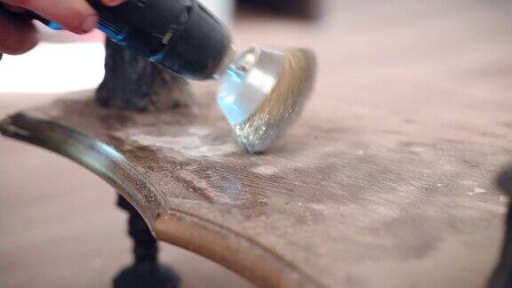 木匠用磨床打磨木桌表面金属圆嘴去除表面残留的旧漆车间修复古色古香的青铜桌腿的过程