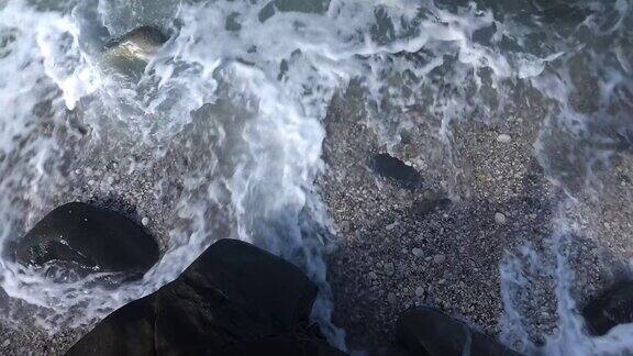 日出时海浪拍打着岩石海岸海水冲刷着布满岩石的狂野海滩地中海沿岸阴暗的海湾