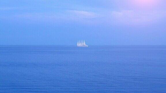 在一个晴朗的夏日帆船在平静完美的蓝色大海上行驶在远处