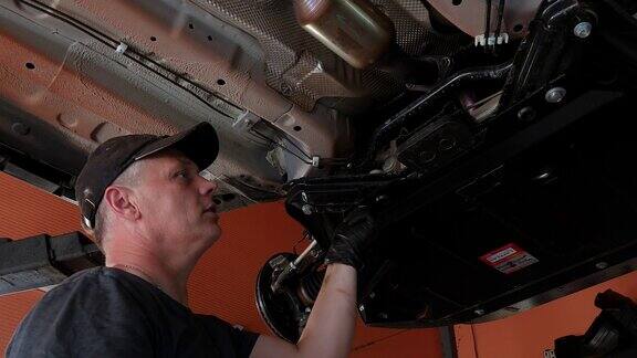 一名汽车维修工人拧紧曲轴箱保护螺栓修理汽车百余辆