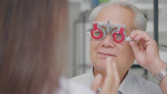 图为一位女验光师在一家眼镜店用医疗器械检查老年男性的视力