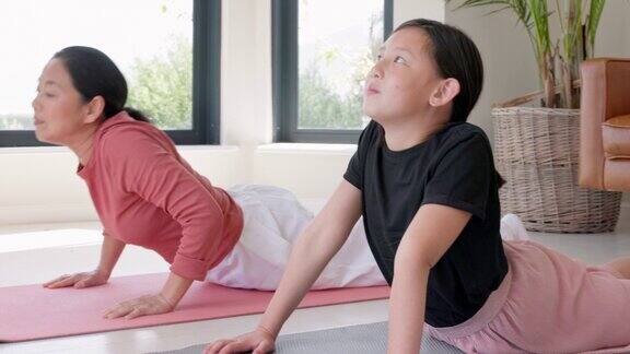 健身家庭和亚洲瑜伽由母亲和女儿在地板上锻炼冥想和健康锻炼在家里普拉提女孩和妈妈训练放松和和平与禅宗心灵和健康在日本