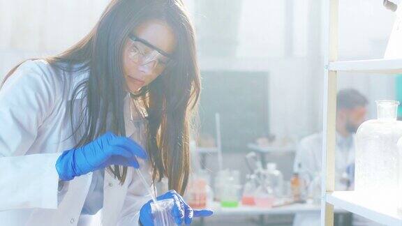 化学反应生物技术女士在她工作的实验室里把一些液体集中在玻璃浴盆上由ARRIAlexaMini拍摄