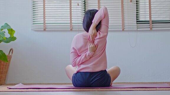 平静的亚洲女性在休闲伸展肌肉热身呼吸和冥想与瑜伽在家健康的女性做瑜伽感觉如此舒适和放松健康瑜伽保健概念