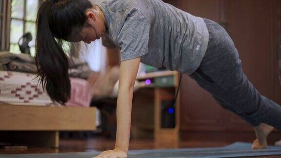 亚洲妇女在家里做有氧运动HIIT训练以减肥和调整身体