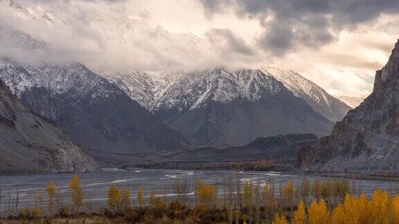 在巴基斯坦罕萨山谷的秋天喀喇昆仑山脉雪山壮丽景色的时间流逝移动云日出场景