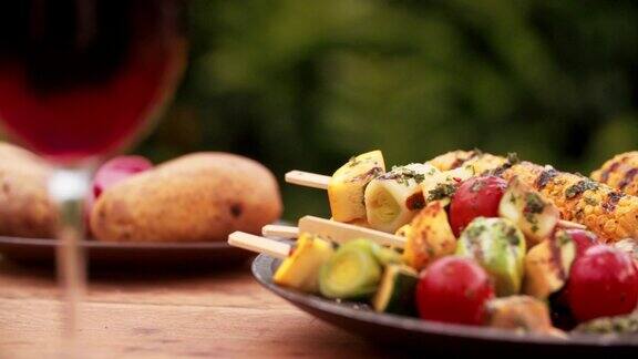 一盘健康的烤蔬菜放在户外的木桌上