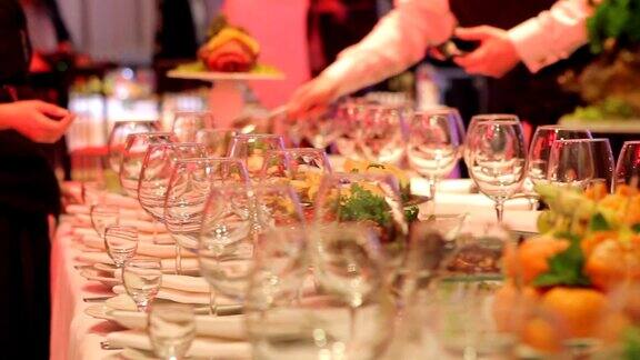 服务员在餐厅宴会桌上安排酒杯空酒杯放在宴会桌上新年、圣诞节