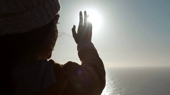 女人透过手看太阳