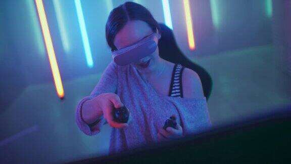 美丽的职业玩家女孩戴着虚拟现实耳机玩在线视频游戏用控制器做手势房间里的复古霓虹色很酷