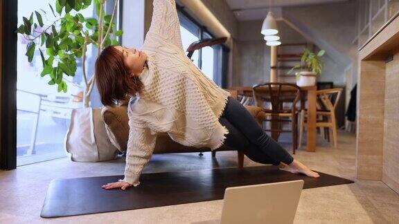 一名日本女子在客厅里上在线瑜伽课