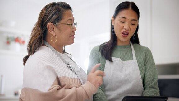平板电脑烹饪和搜索与高级母亲与女儿在厨房学习食物和食谱博客烘焙营养和帮助妇女在家里的技术健康和膳食准备