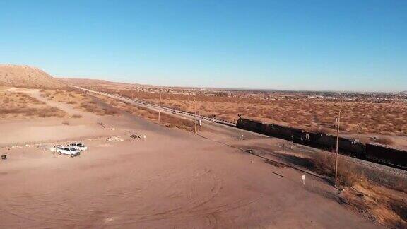 一列货运火车沿着新墨西哥州桑兰公园的美墨边境墙行驶