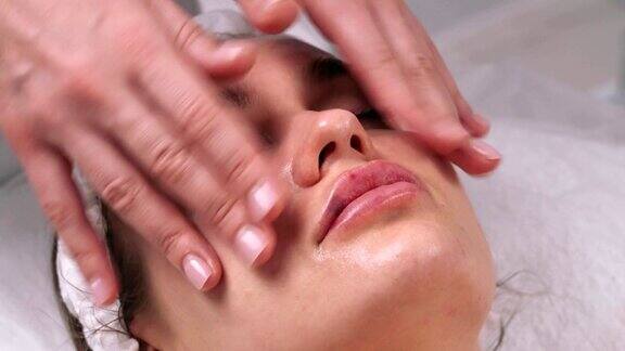 整容手术面部按摩一个女人在美容院给她敷面膜面罩的应用程序