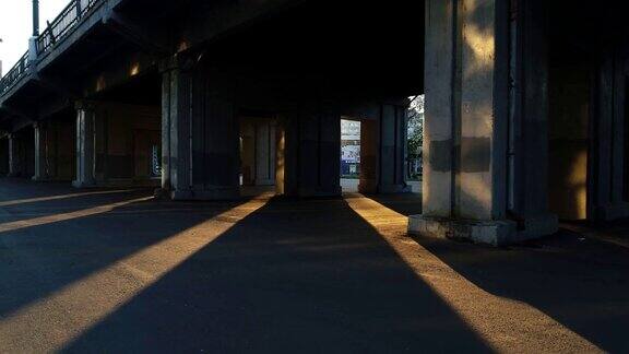 在混凝土桥下阳光透过桥墩明亮地照耀着