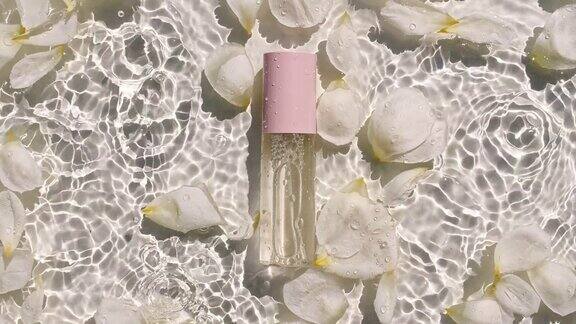 玫瑰花瓣在水面上以水滴的形式绽放化妆品瓶油液胶原蛋白血清瓶女性化妆品、护肤品布局美容产品样品