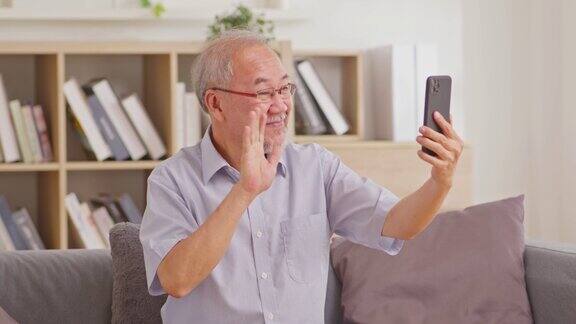 亚洲老人在家时通过智能手机进行视频通话、在线通话、数字技术服务咨询微笑成熟视频电话会议聊天在线聊天概念