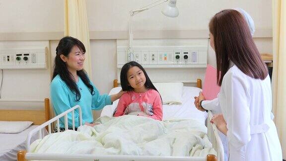 女医生在病床上对生病的孩子说话