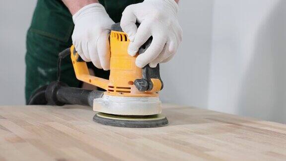 木工在室内用磨床打磨木板表面