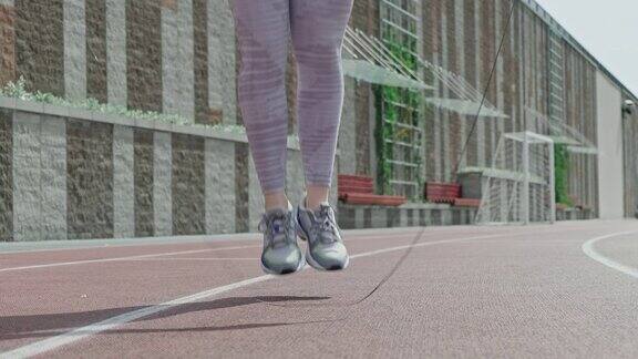 特写的女性脚跳绳在体育场运动训练