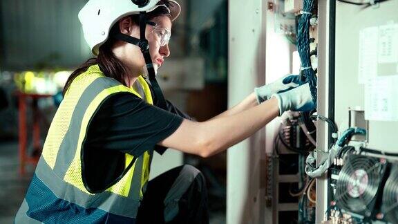 一名白人电气工程师正在检查机械臂控制柜的接线以解决电气故障