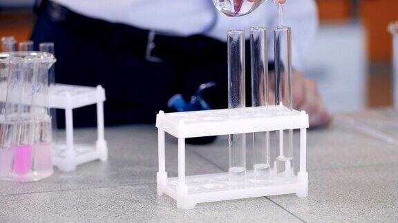 用手将化学试剂放入试管中学生在实验室做化学测试