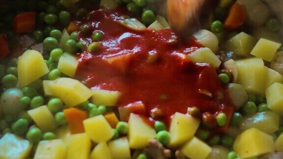 番茄酱和豌豆、土豆、胡萝卜和肉一起加入到这道菜中