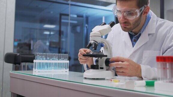在实验室工作的科学家医生使用显微镜进行医学研究实验室工具:显微镜试管设备生物技术、化学、科学、实验和医疗保健概念