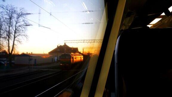 从移动的现代火车窗口看到美丽的红色日落天空的倒影对面的座位是空的慢动作
