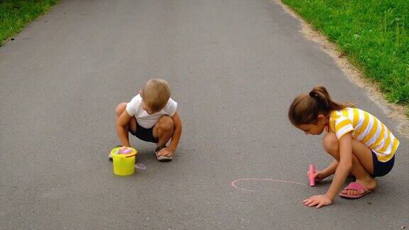 孩子们用粉笔在柏油路上画画有选择性的重点的孩子
