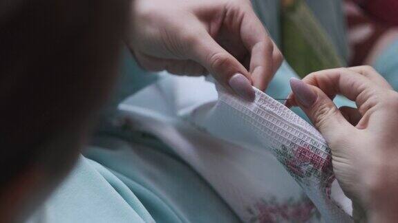 年轻女子用慢动作用线和针手工缝制