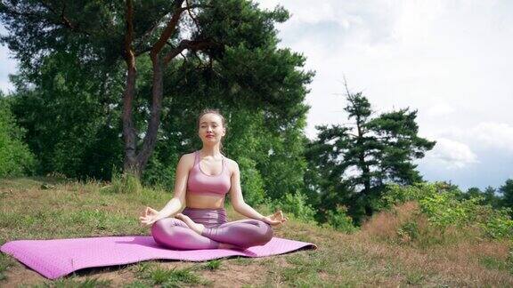 运动女子微笑冥想莲花姿势与闭上的眼睛