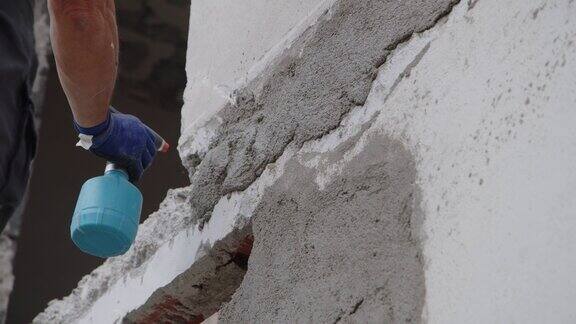 建筑工人在房屋工地用抹刀涂抹砂浆