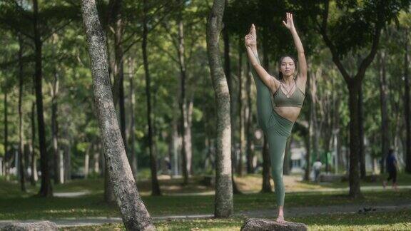 周末早上一名亚裔华裔女子在公园里练习瑜伽