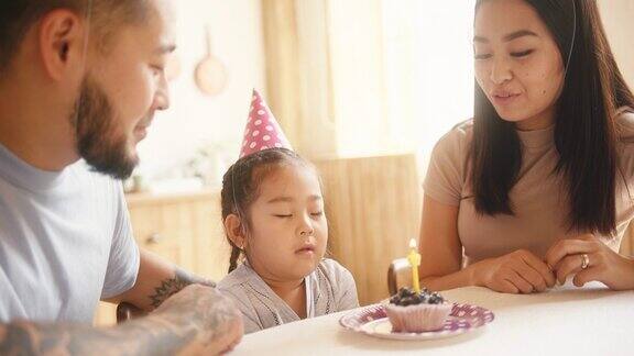 亚洲小孩和父母一起庆祝生日吹蜡烛
